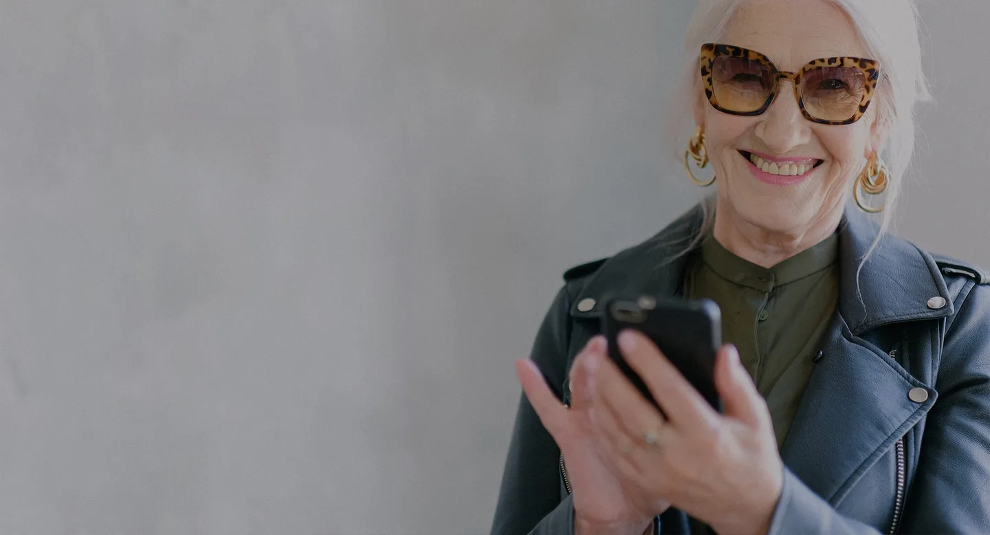 A woman smiling while looking at her phone