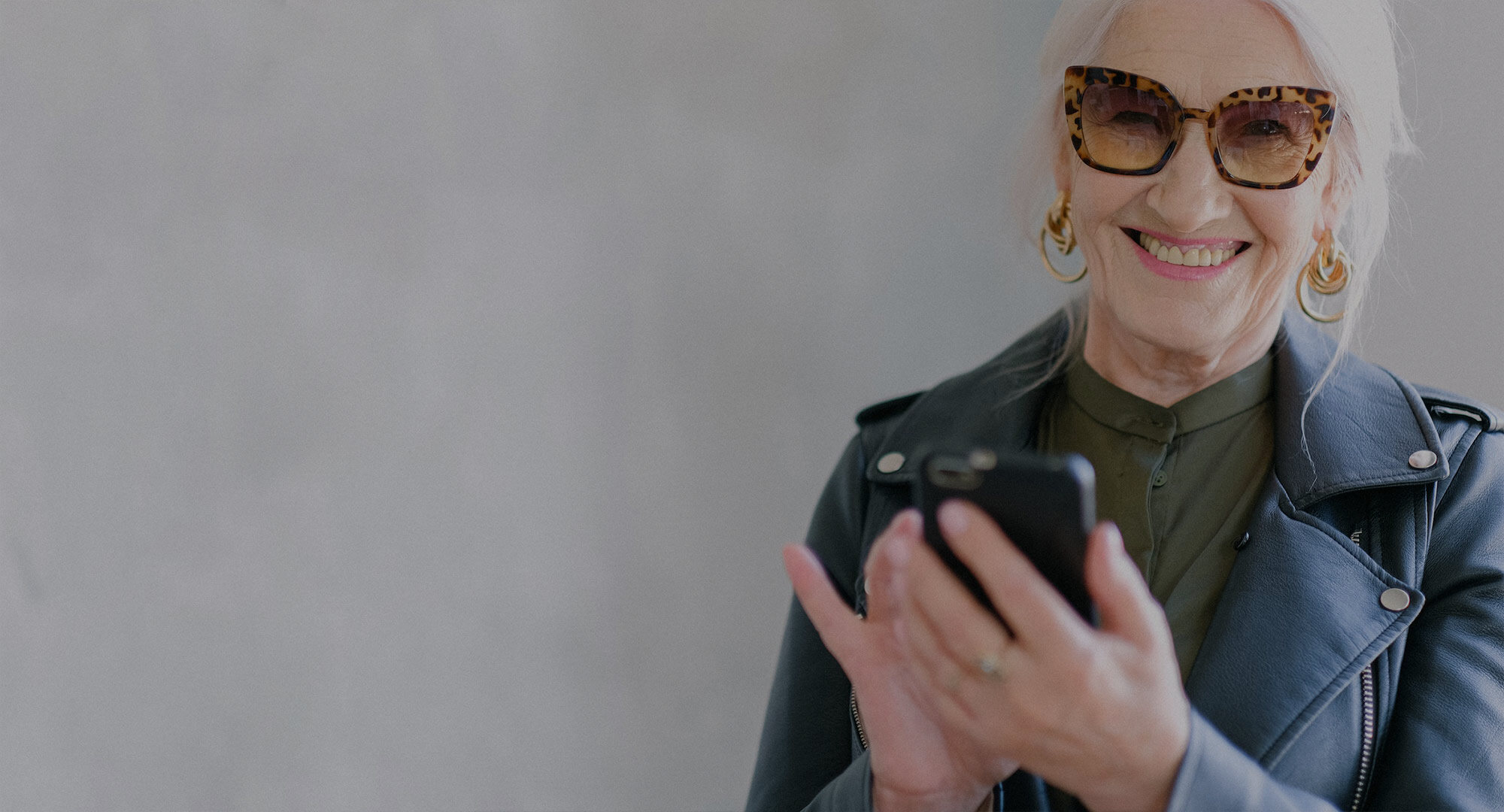 A woman smiling while using her phone